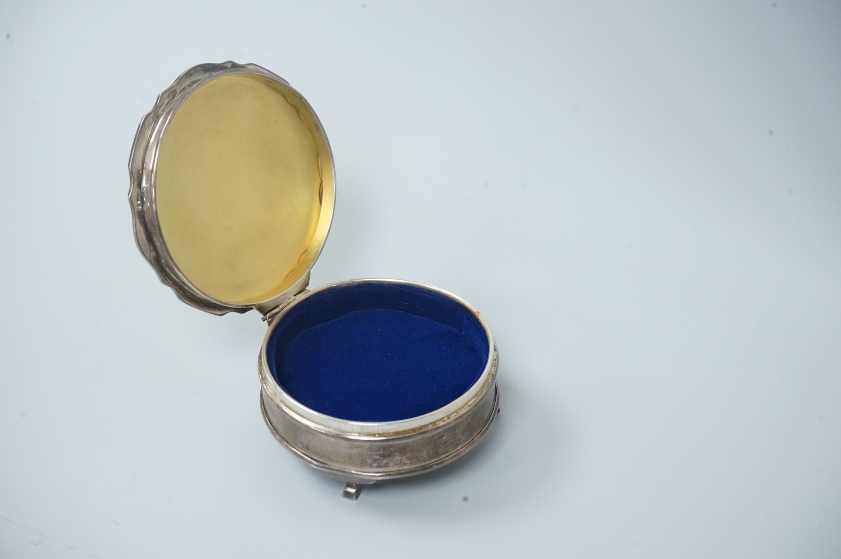 A George V silver mounted trinket box, by Adie Brothers, Birmingham, 1924, diameter 89mm. and a chrome magnifying glass, later added to a knife handle, handle by Goldsmiths & Silversmiths Co Ltd, London, 1894, 21.7cm.